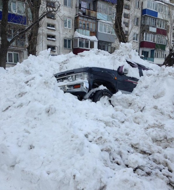 В Южно-Сахалинске экскаватор вместе со снегом снес с обочины внедорожник
